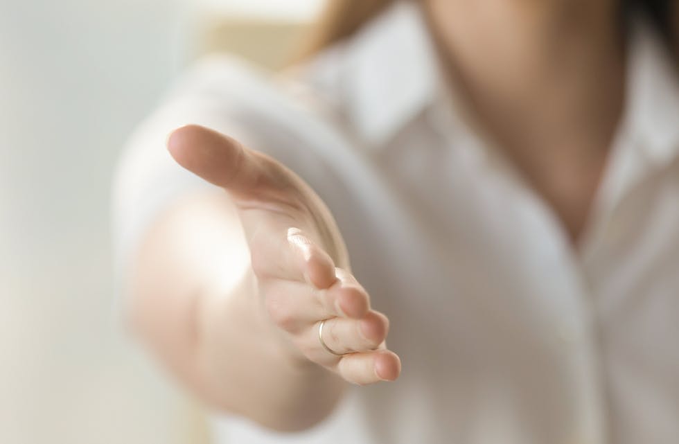 Close up businesswoman holds out her hand for handshake