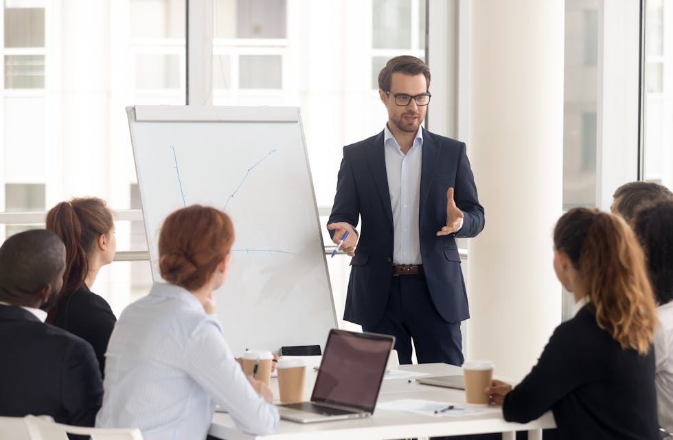 Male business coach speaker in suit give flipchart presentation